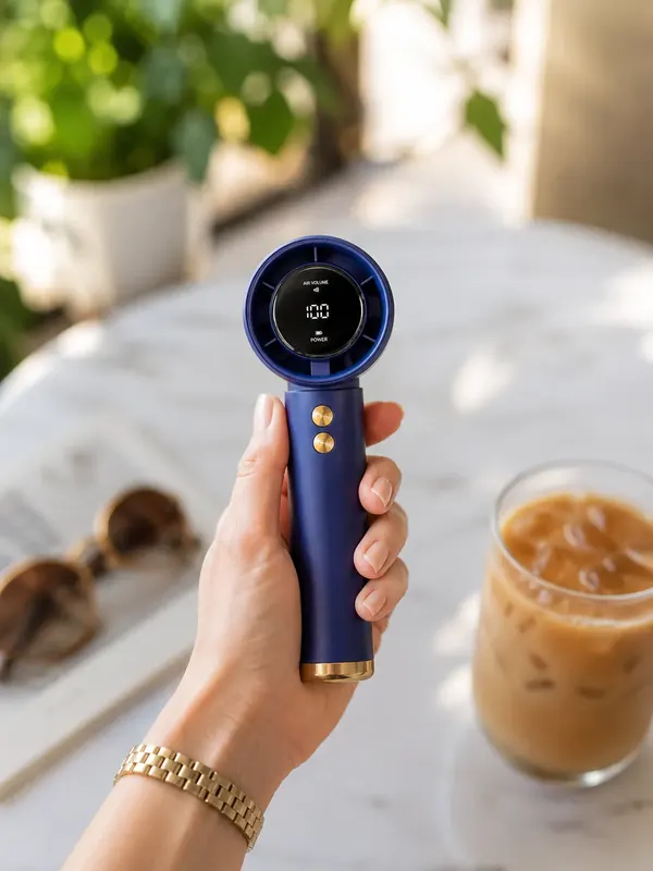 Glacé portable fan held in hand outdoors with iced coffee